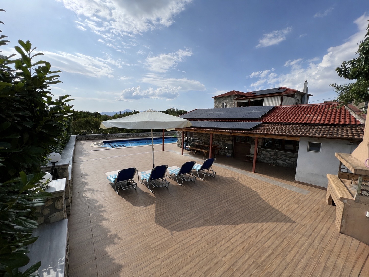 Large terrace with outdoor kitchen Large tiled pool terrace with sun loungers, parasol, outdoor kitchen and stone-built villa