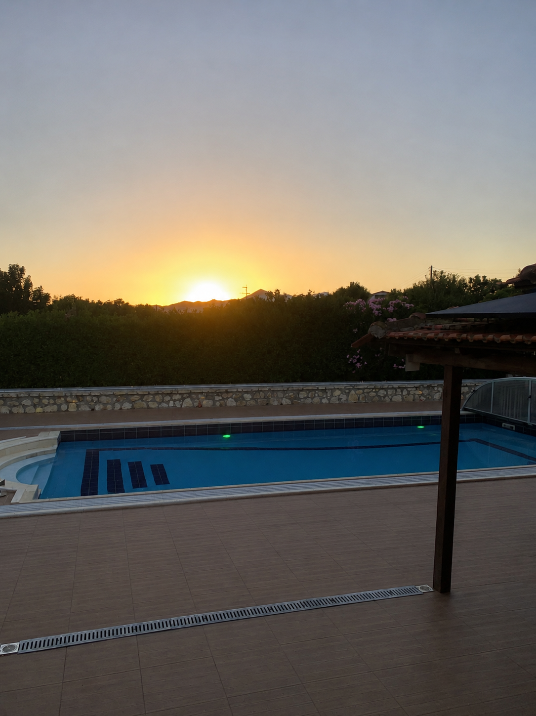 Pool with retractable enclosure Golden hour over the pool with the retractable glass pool enclosure folded back