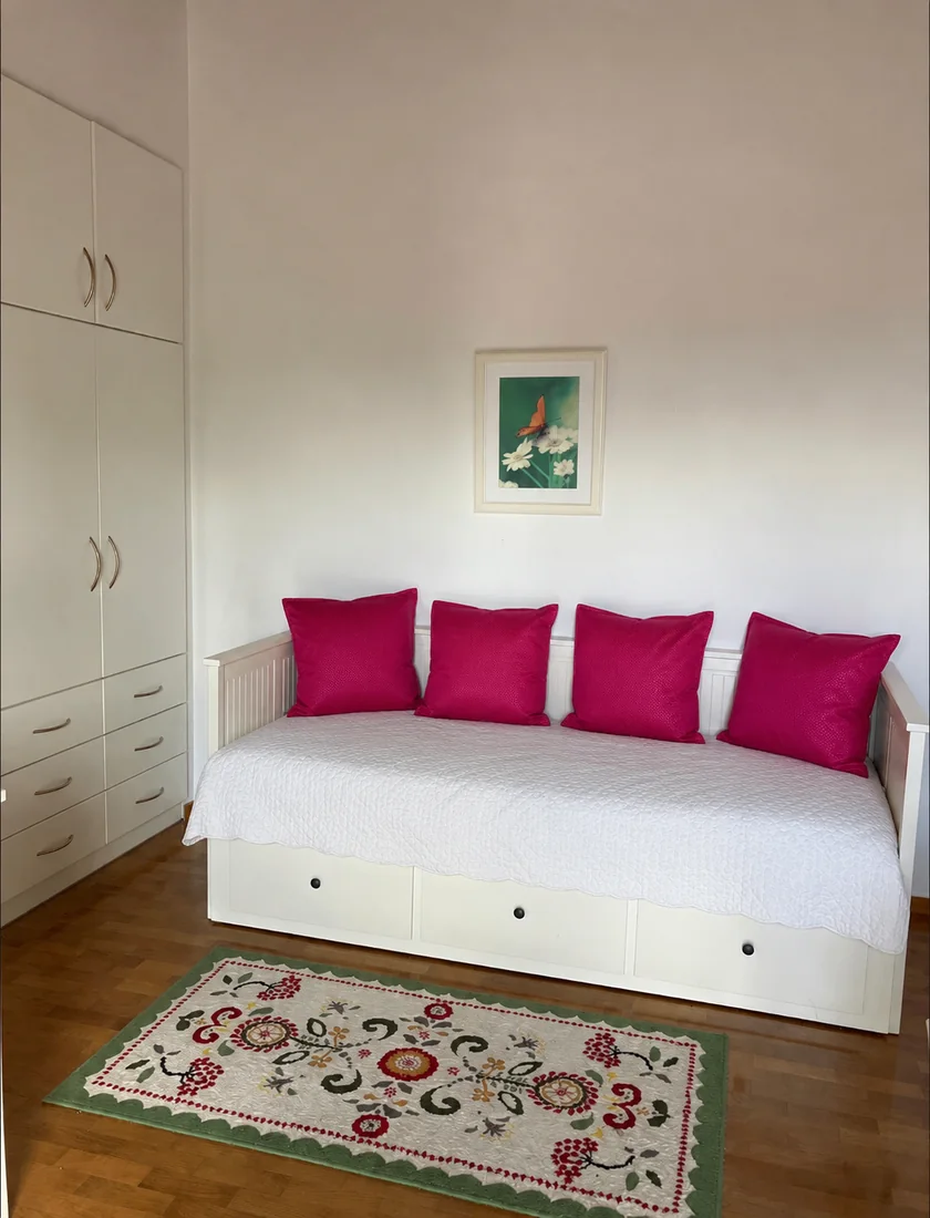 Guest room daybed with pink cushions at Villa Arcadia Guest room daybed with bright pink cushions and patterned rug at Villa Arcadia