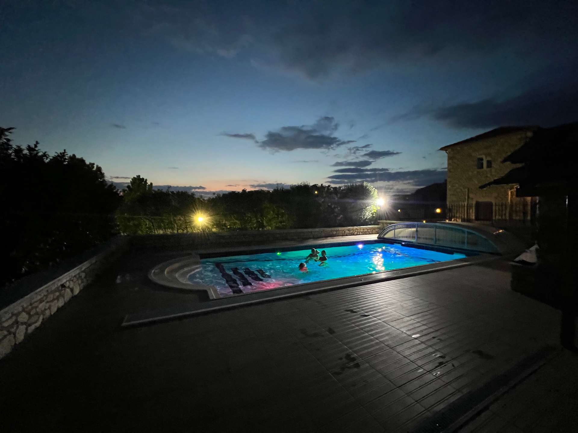 Pool at night Villa Arcadia pool lit blue at night with guests swimming under a twilight sky
